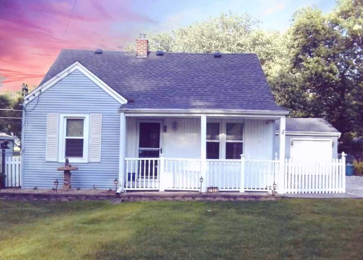 a front view of a house with a garden and yard