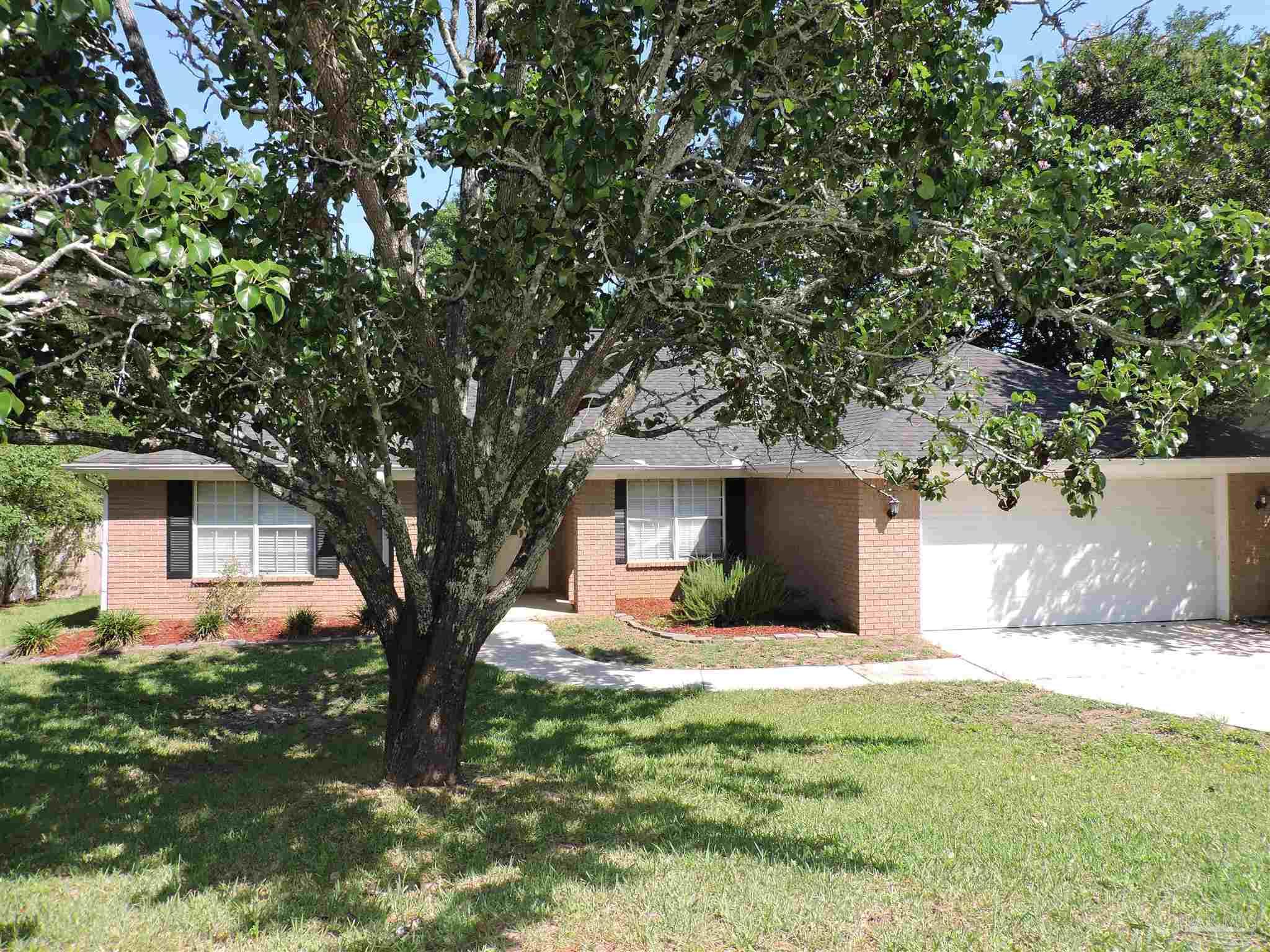 a front view of a house with yard and green space