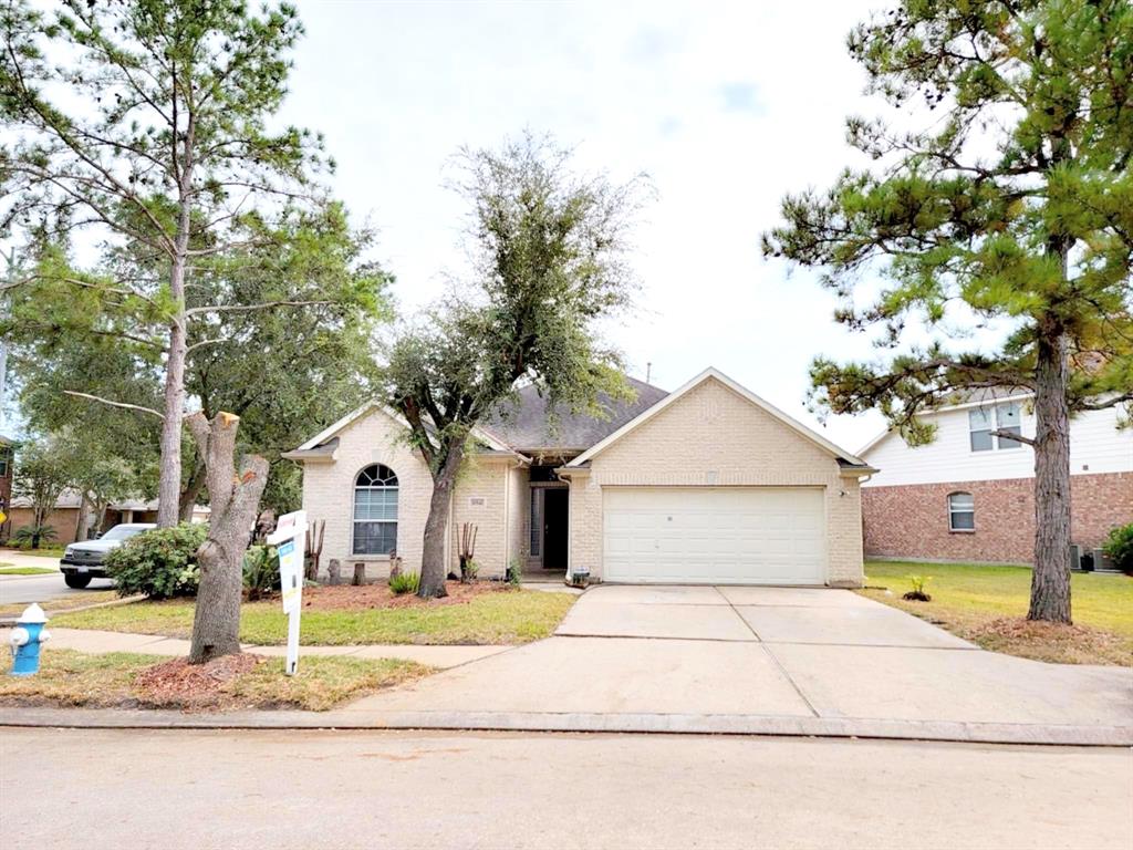 a view of front a house with a yard and garage