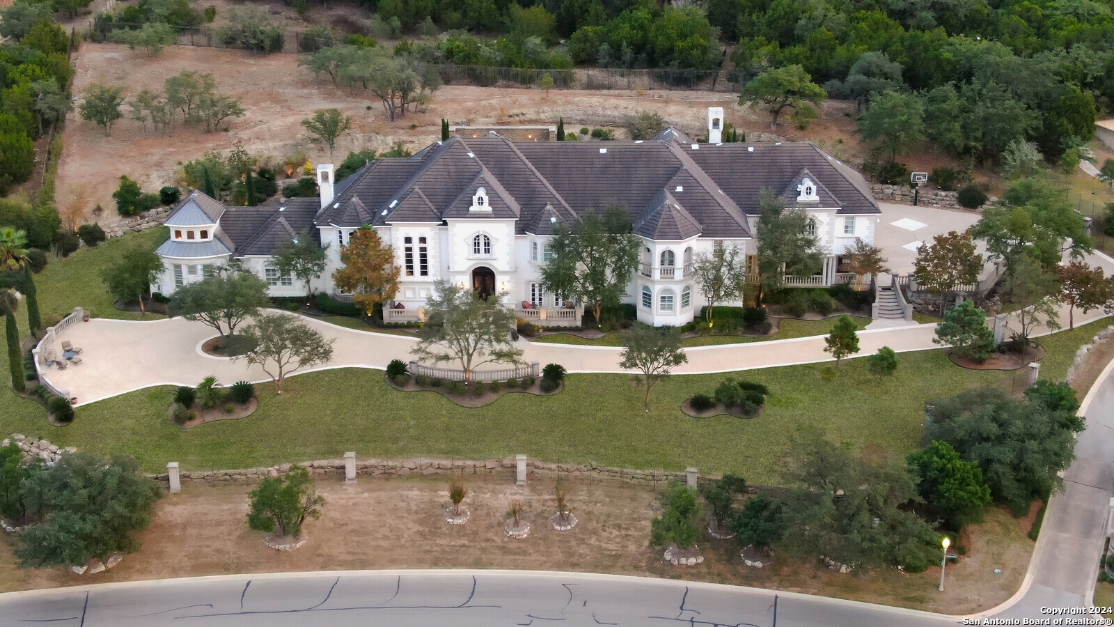 an aerial view of residential houses with outdoor space and parking