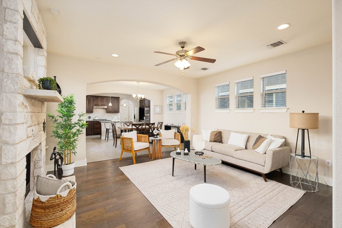 a living room with furniture kitchen view and a chandelier