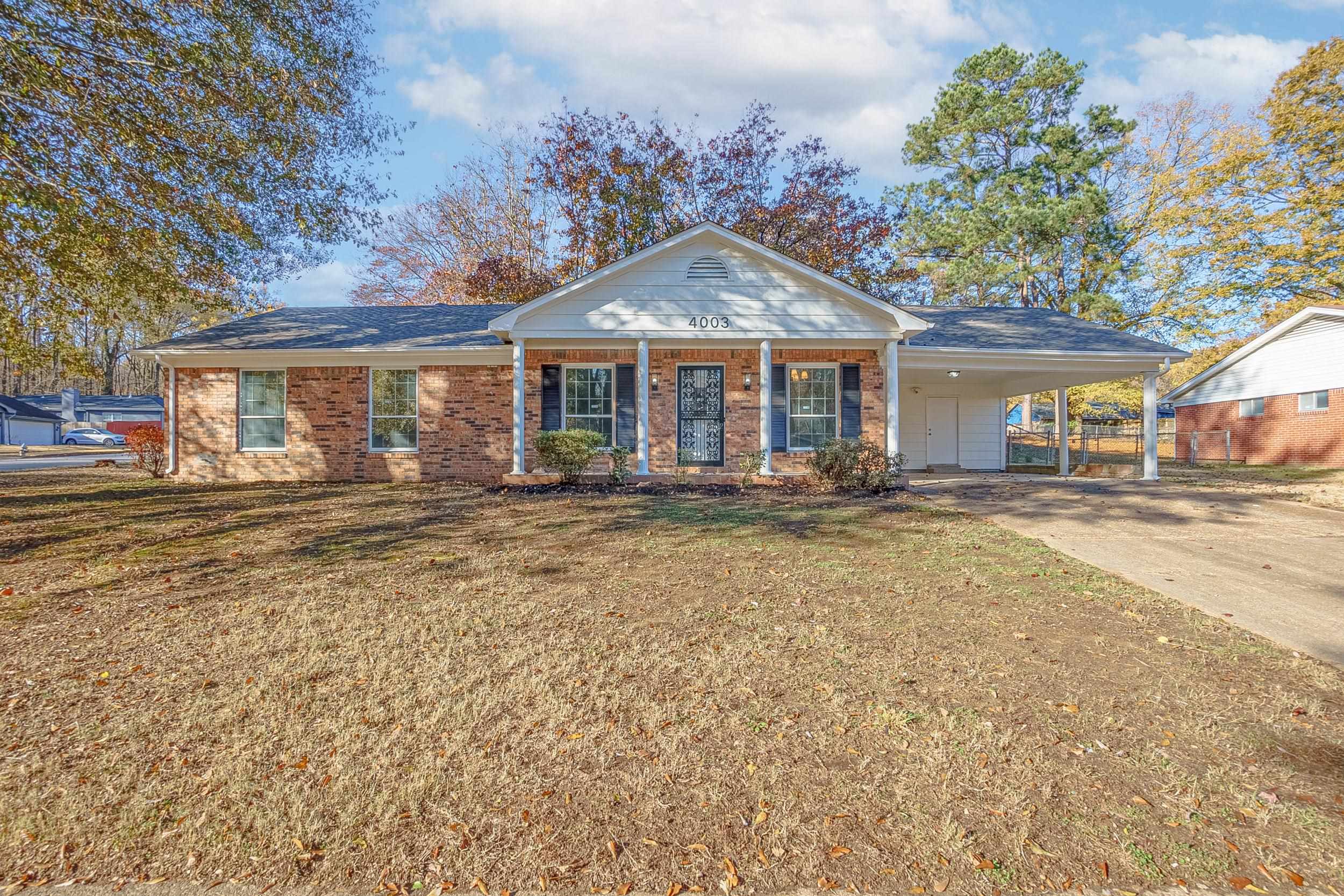 Ranch-style home with a carport, a porch, and a front yard