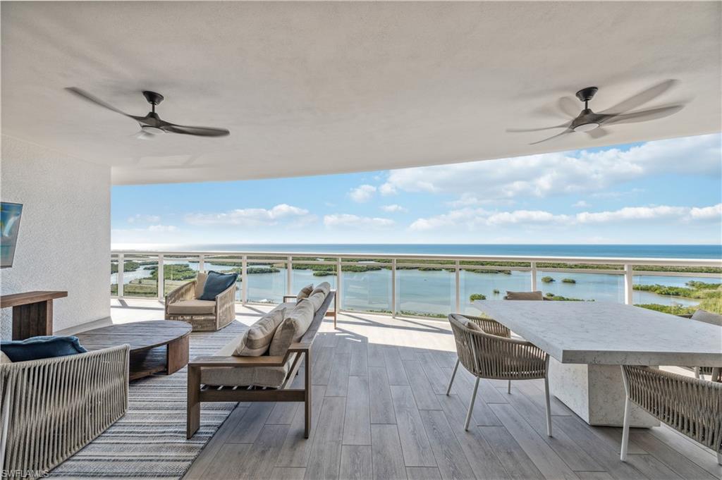 Balcony with ceiling fan, a water view, and an outdoor living space