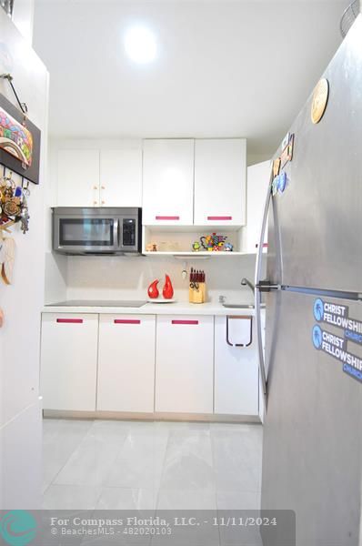 a kitchen with cabinets a sink and white appliances