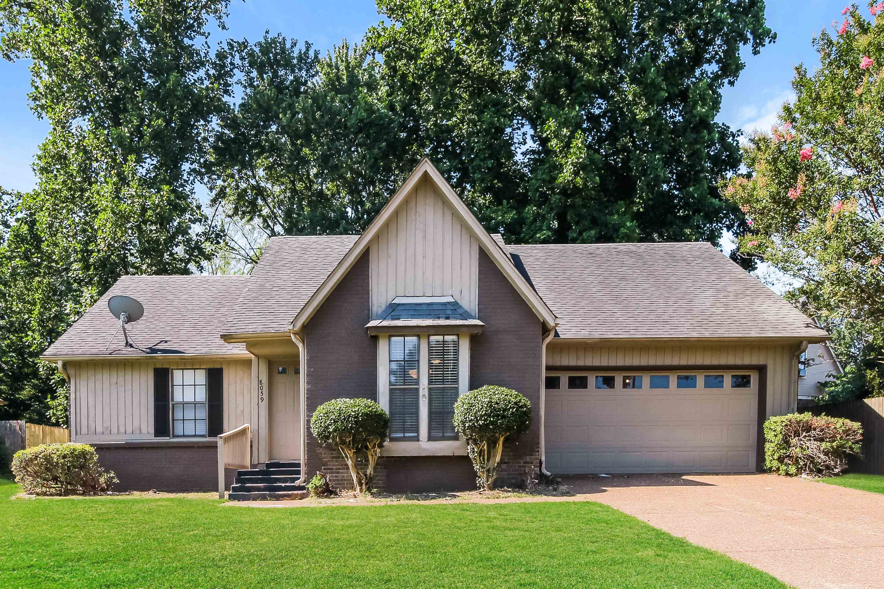 View of front of property featuring a garage and a front lawn