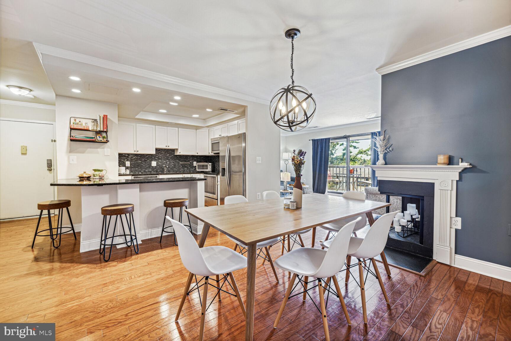 a view of a dining room and livingroom with furniture wooden floor a chandelier