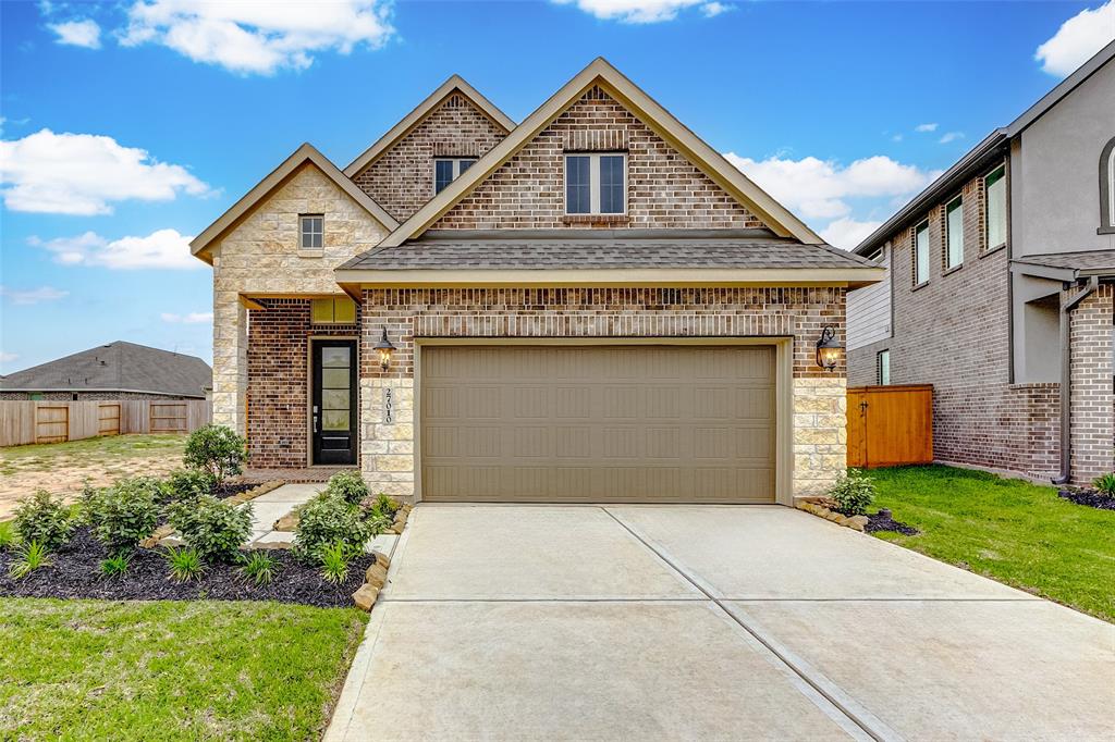 a front view of a house with a yard and garage