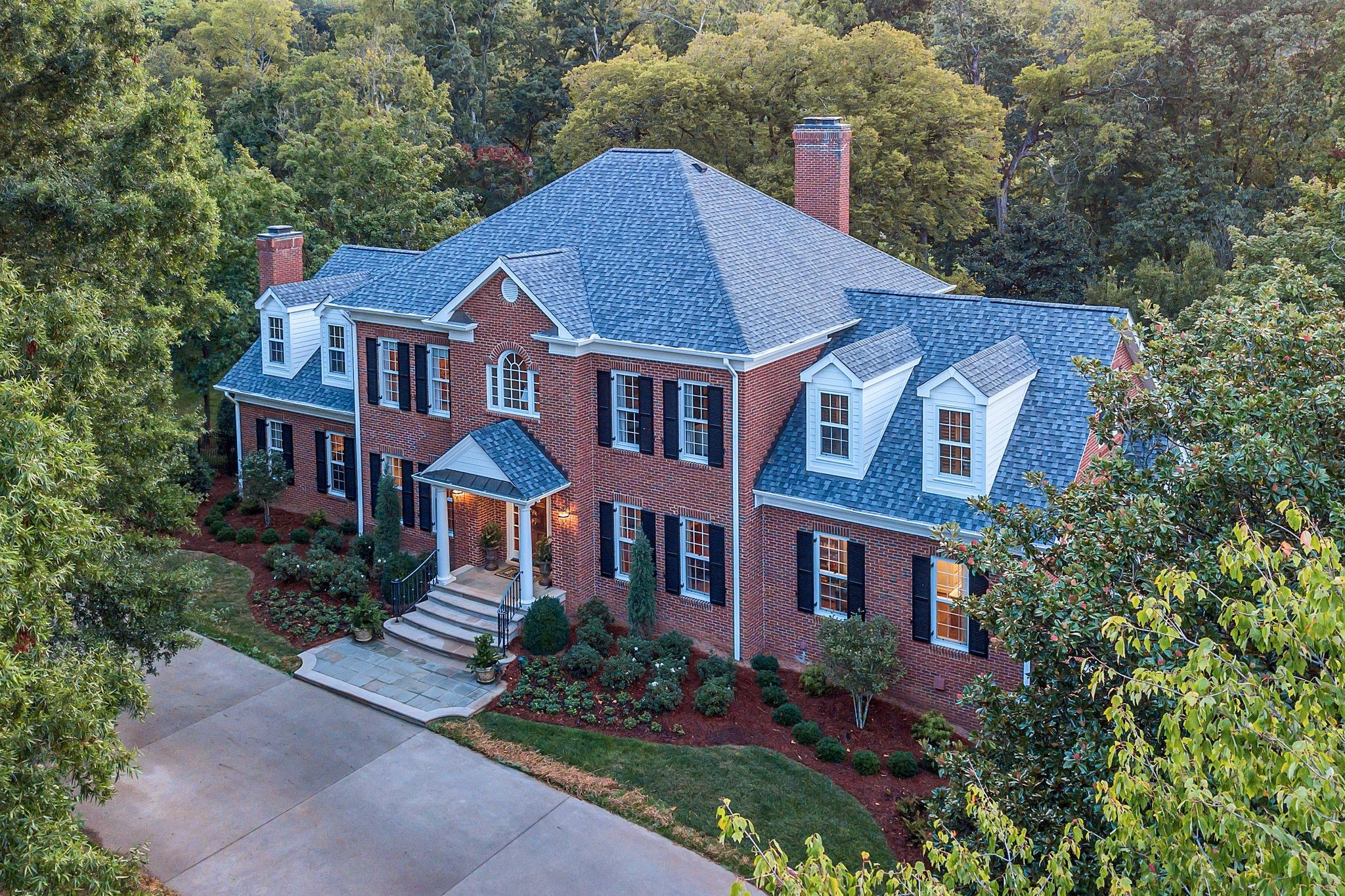 a aerial view of a brick house next to a yard