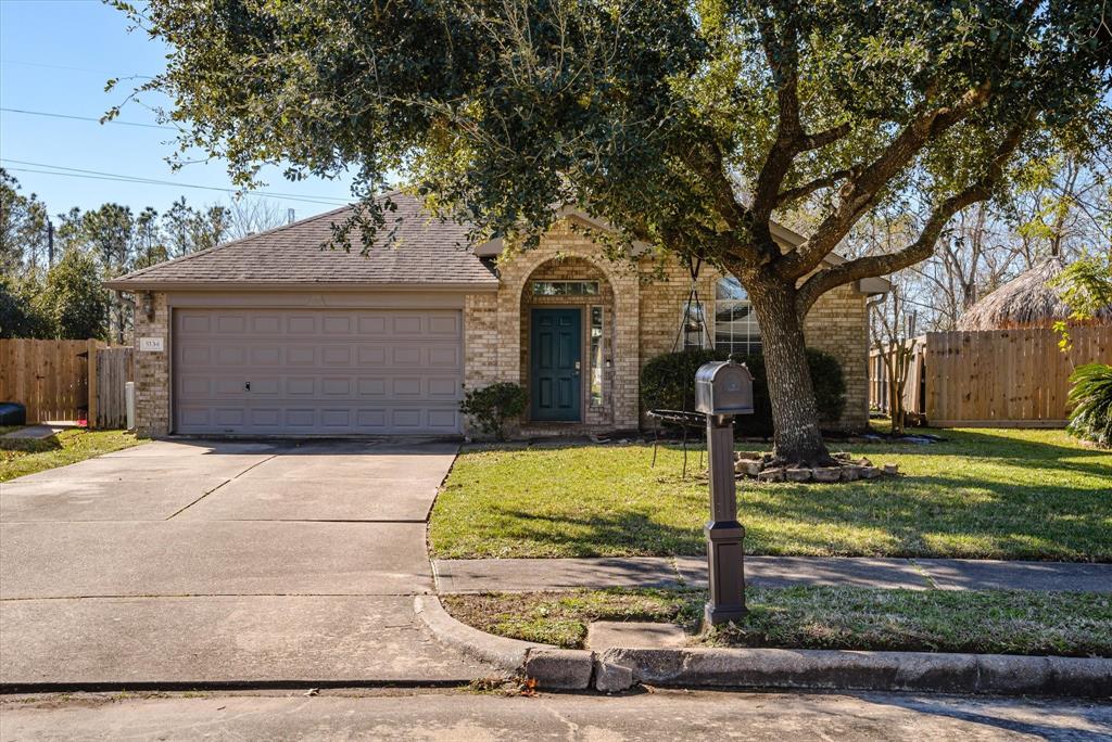 Beautiful brick home with large shade tree in the front yard.