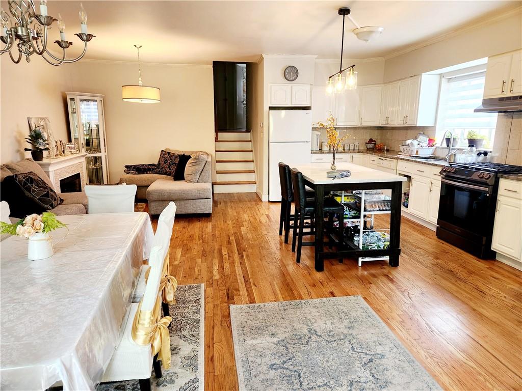 a living room with stainless steel appliances kitchen island granite countertop furniture wooden floor and a view of kitchen