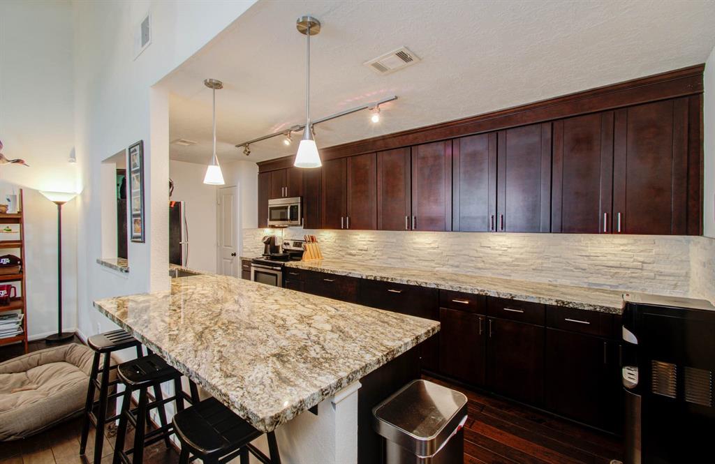 a kitchen with granite countertop kitchen island a table and chairs in it