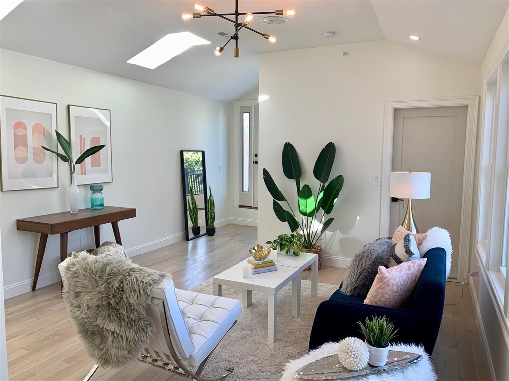 a living room with furniture potted plant and a table