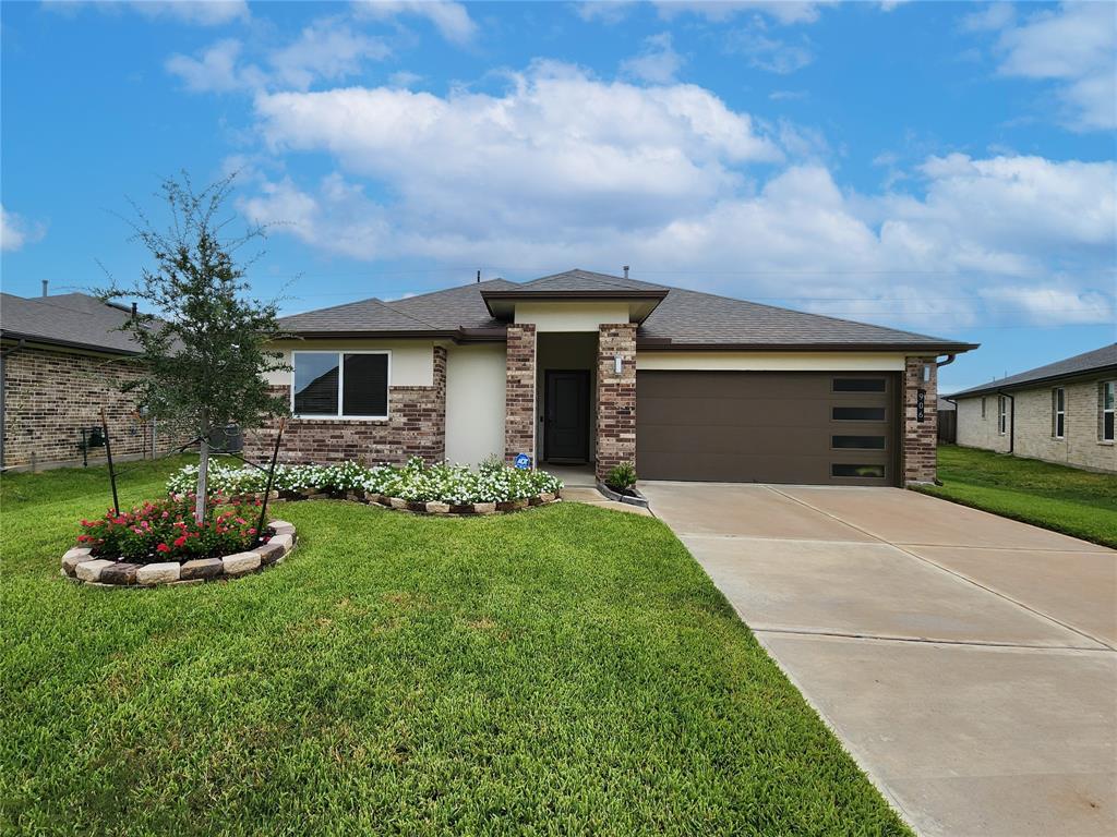 a front view of a house with a garden and yard