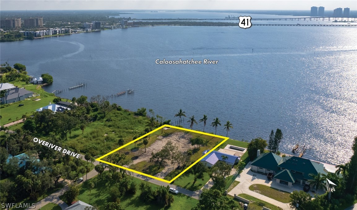 an aerial view of house with yard and ocean view