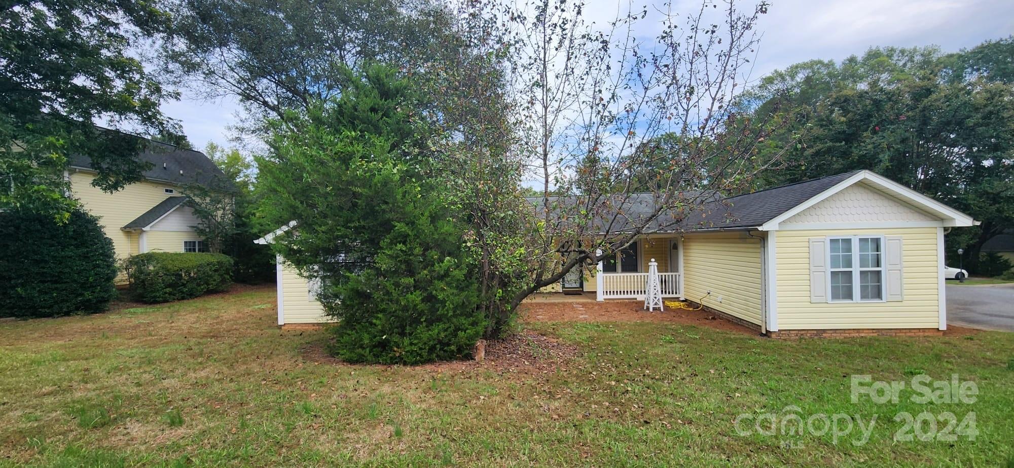 a front view of a house with a yard and trees