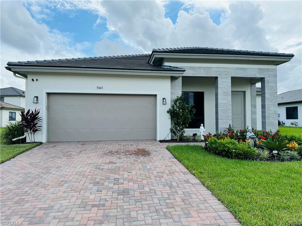 View of front facade with a garage and a front lawn