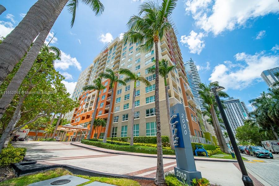 a view of a tall building next to a yard