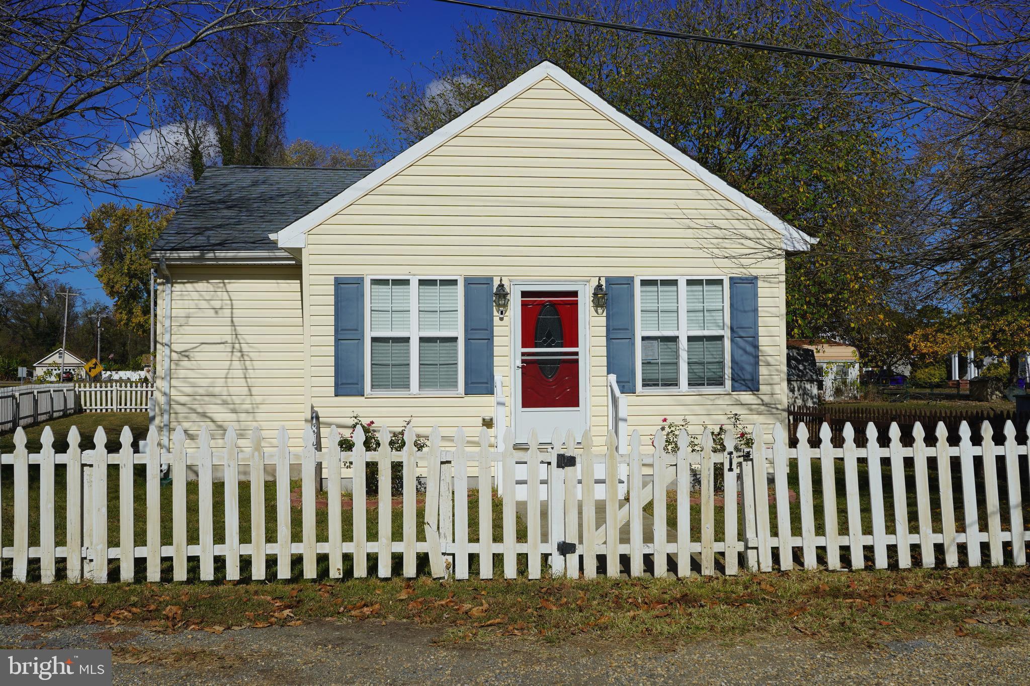 a front view of white house with a small yard