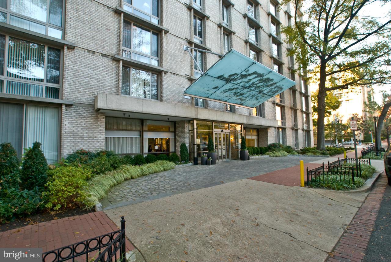 a front view of a building with a garden and plants