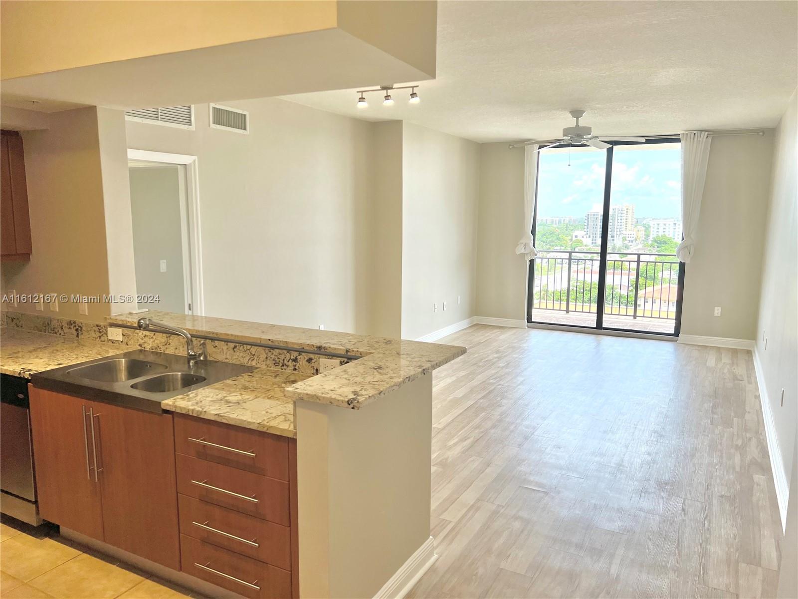 a bathroom with a granite countertop sink and a window