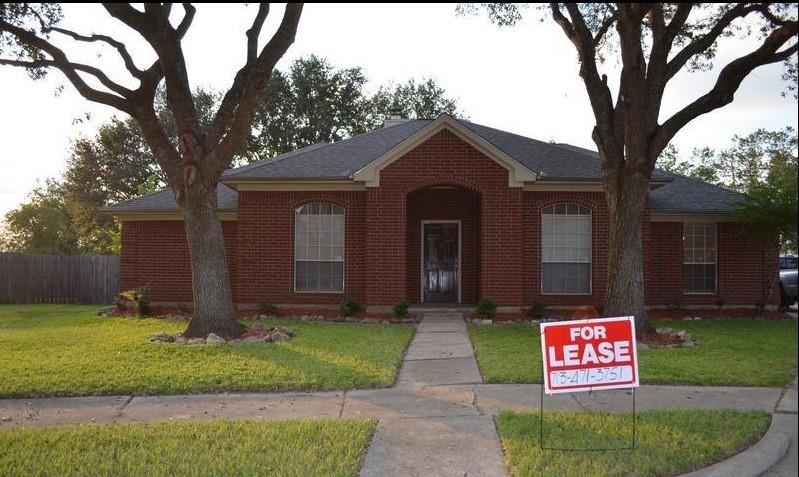 a sign board with a big yard and potted plants