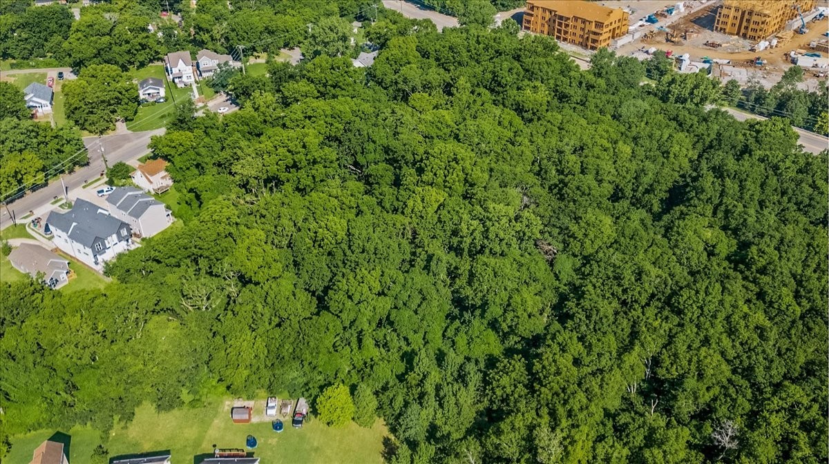 an aerial view of residential house with outdoor space and trees all around