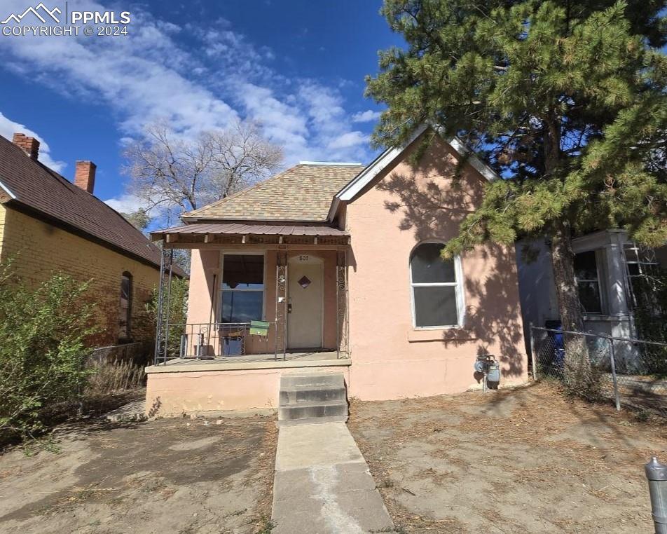 a view of a house with a tree in front of it