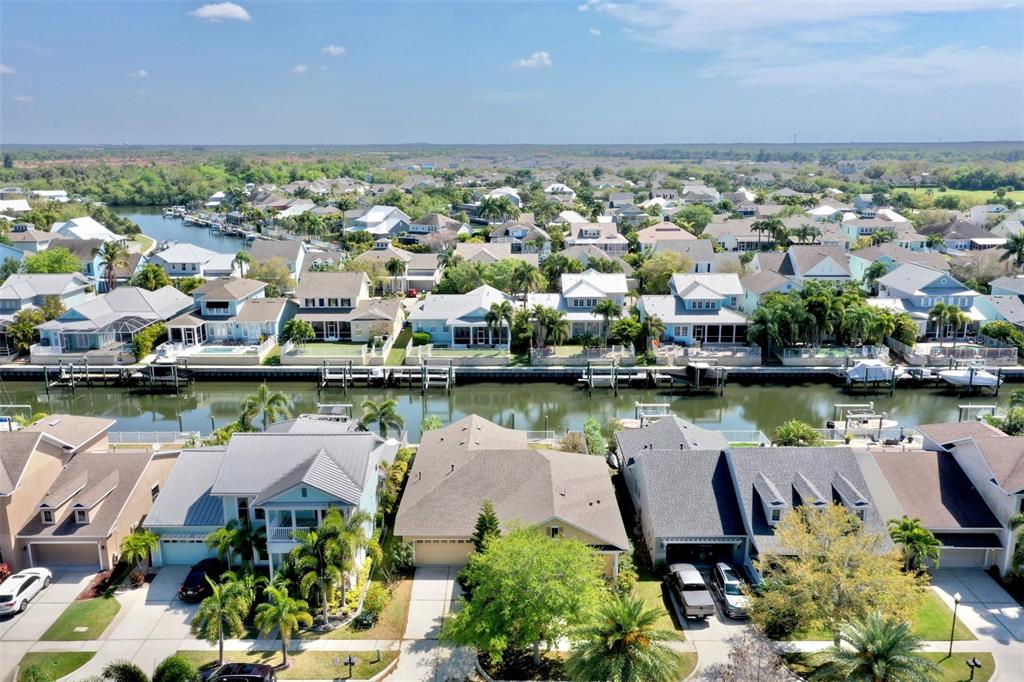 an aerial view of a city with large trees and houses a lake view