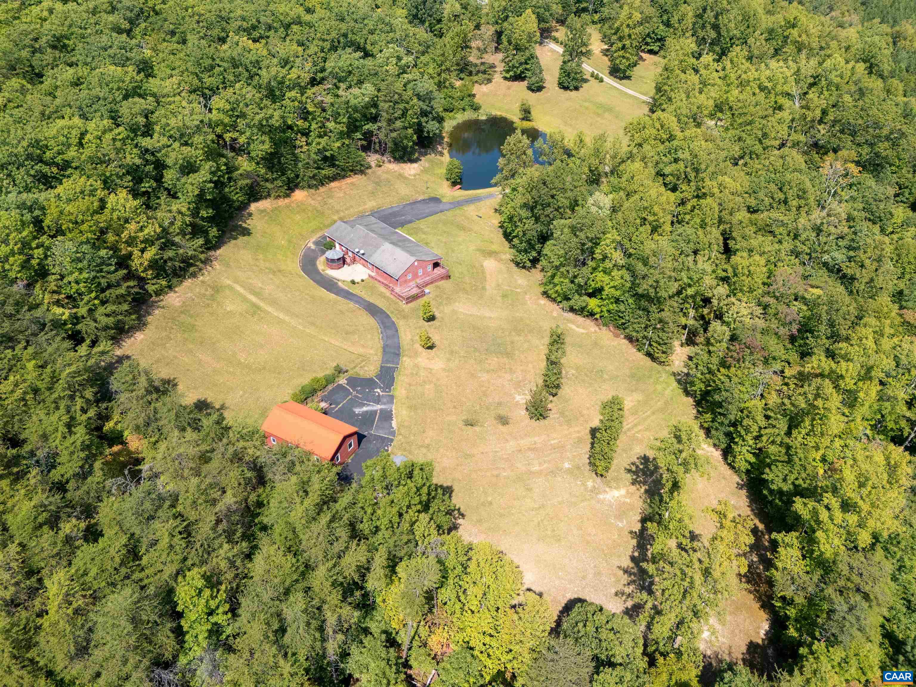 an aerial view of a house with a yard and large trees