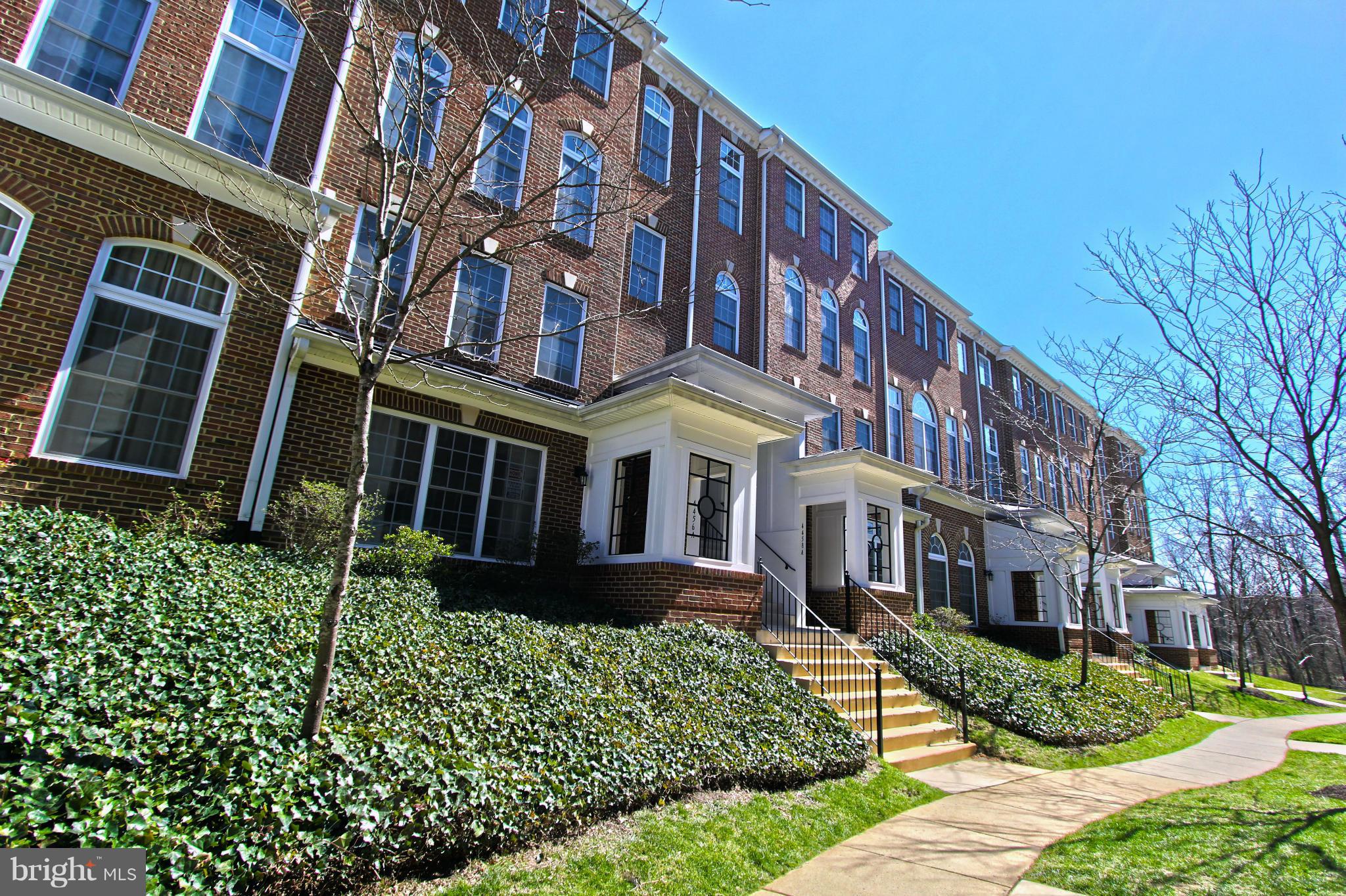 a front view of a multi story residential apartment building with a yard