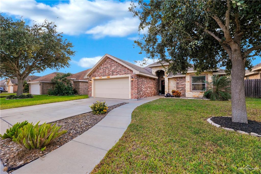 Ranch-style house featuring a garage and a front yard