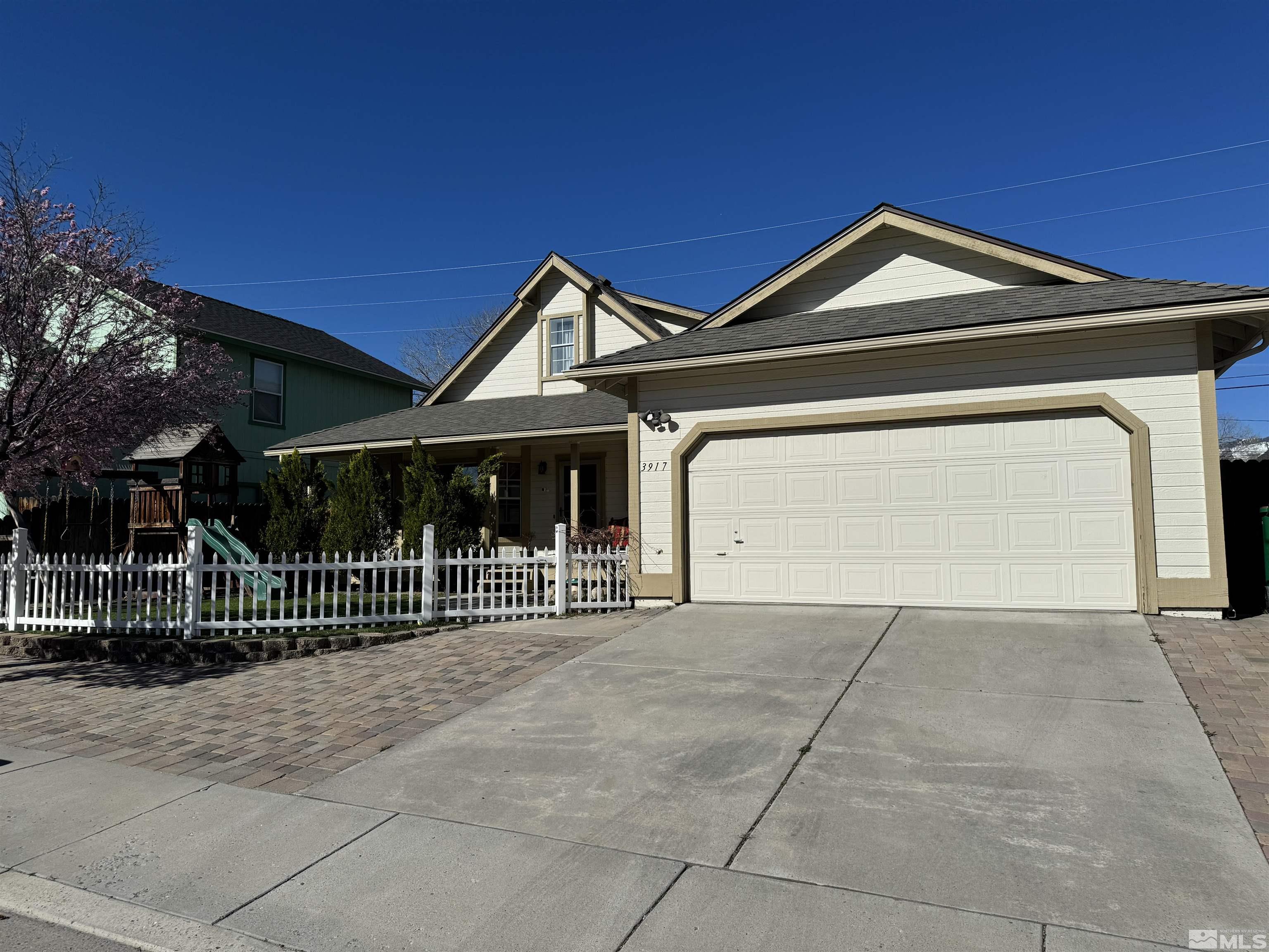 a view of a house with a small yard and wooden fence