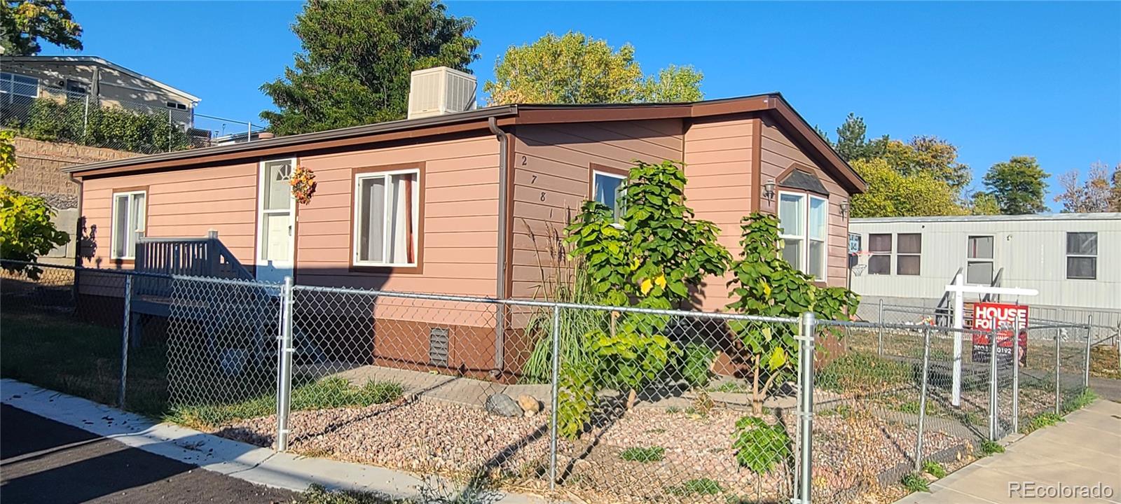 a view of a house with wooden fence next to a yard