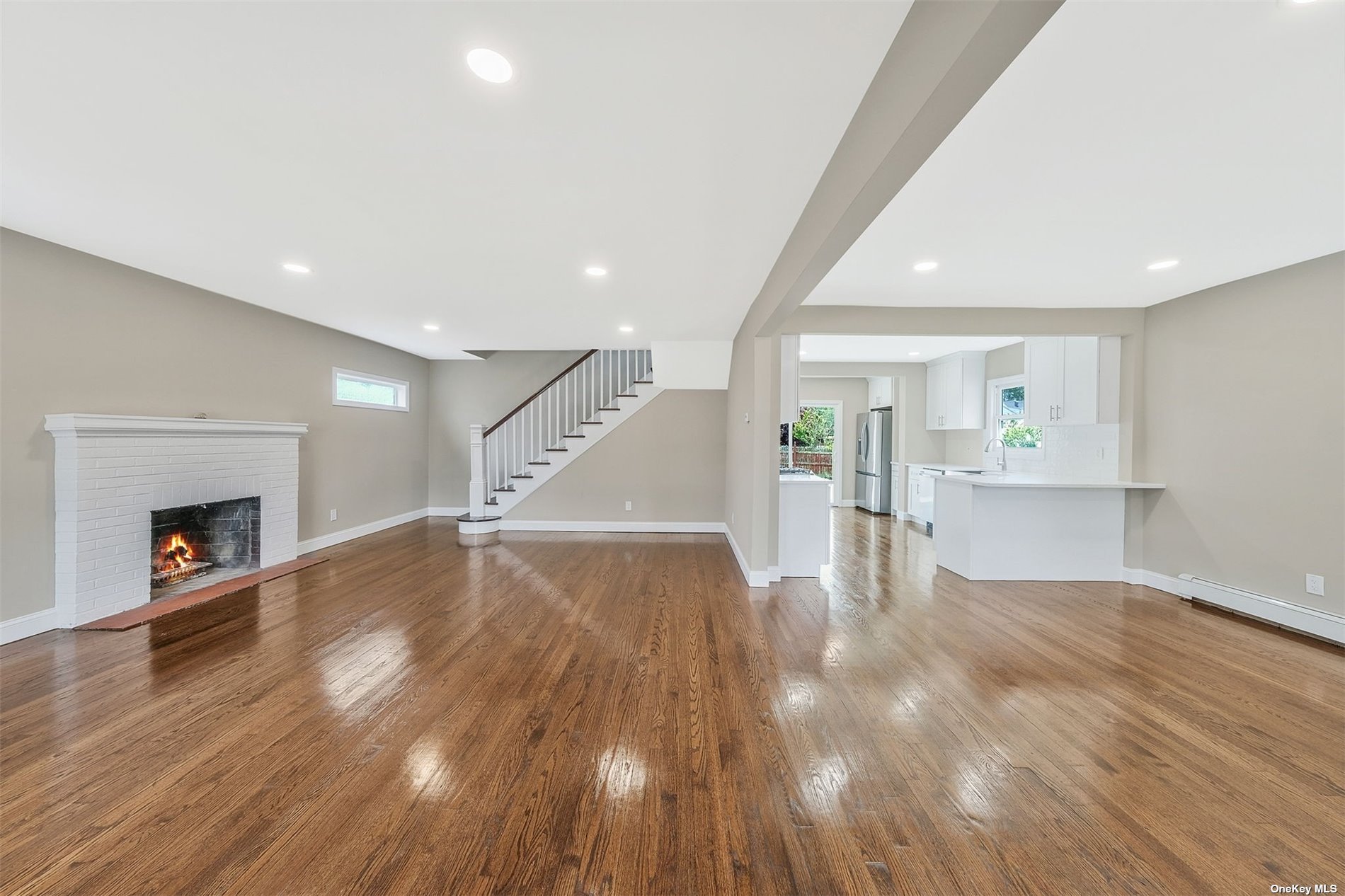 a view of empty room with wooden floor and fireplace