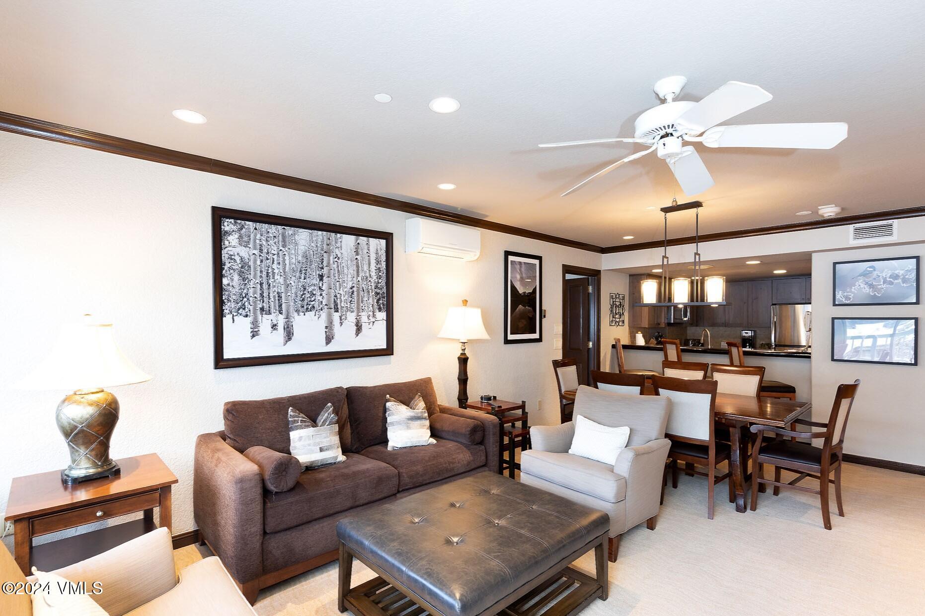 a living room with furniture a chandelier and a dining table