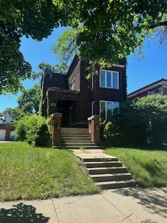 a front view of a house with a yard balcony and trees