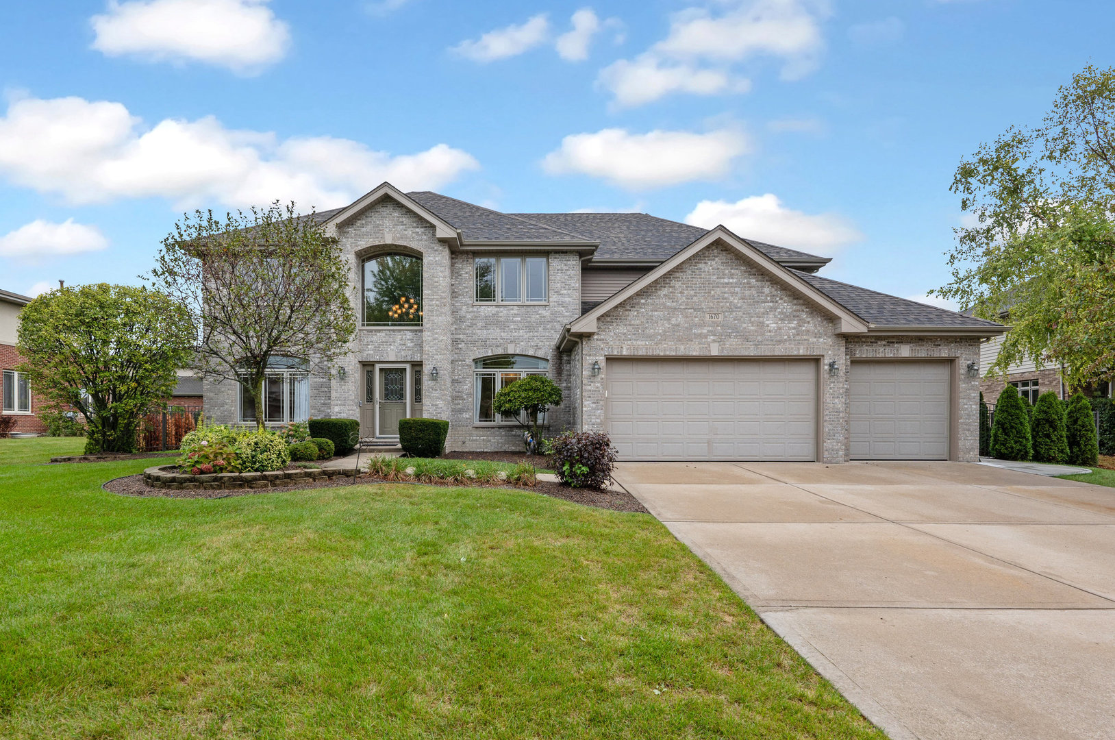 a front view of a house with a garden and yard