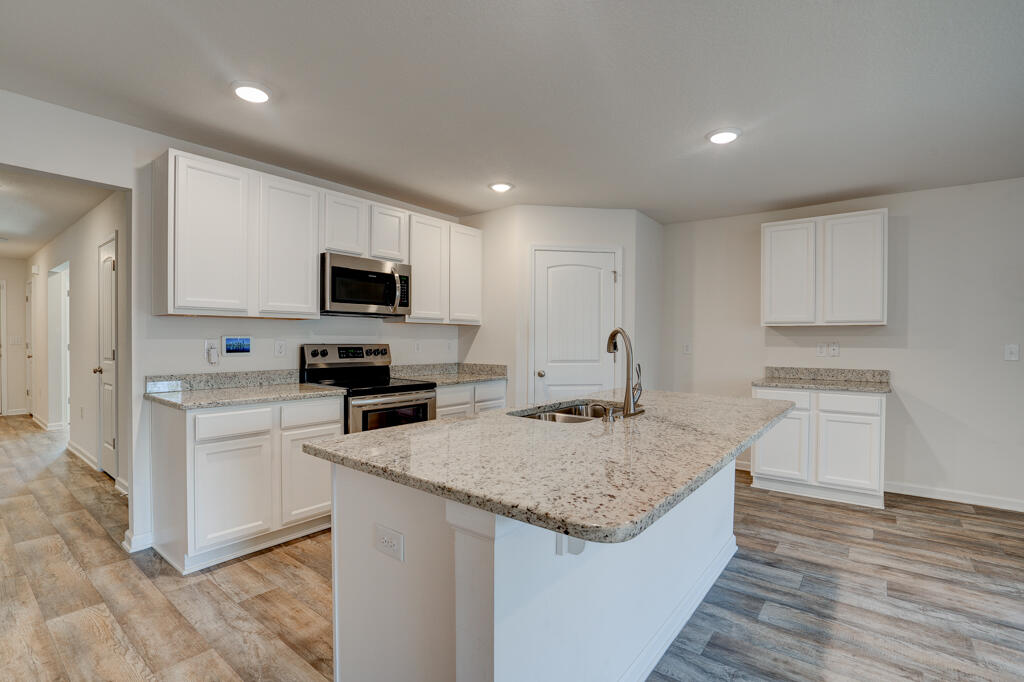 a kitchen with granite countertop a sink and steel appliances