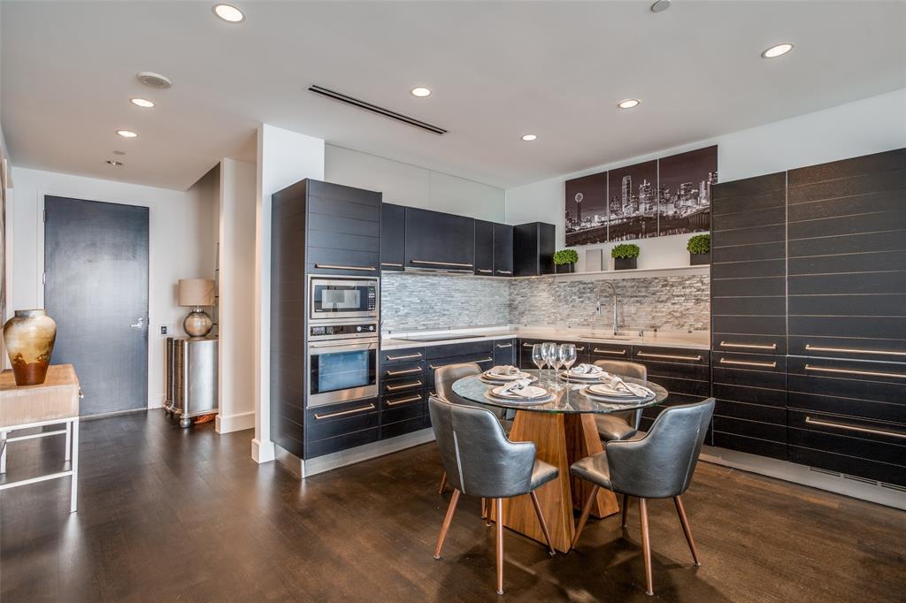 a kitchen with a table chairs a stove a sink and a refrigerator