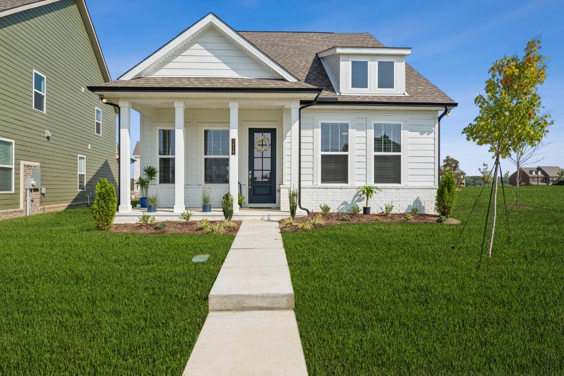 a front view of a house with a yard and potted plants