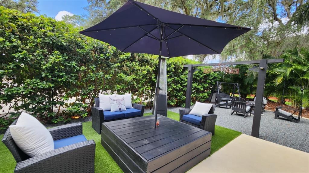 a patio with a table and chairs under an umbrella