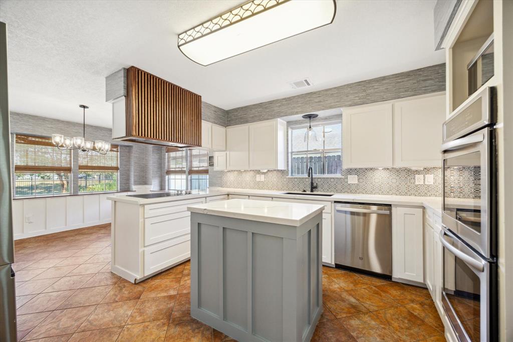 a kitchen with stainless steel appliances granite countertop a stove a sink and a refrigerator