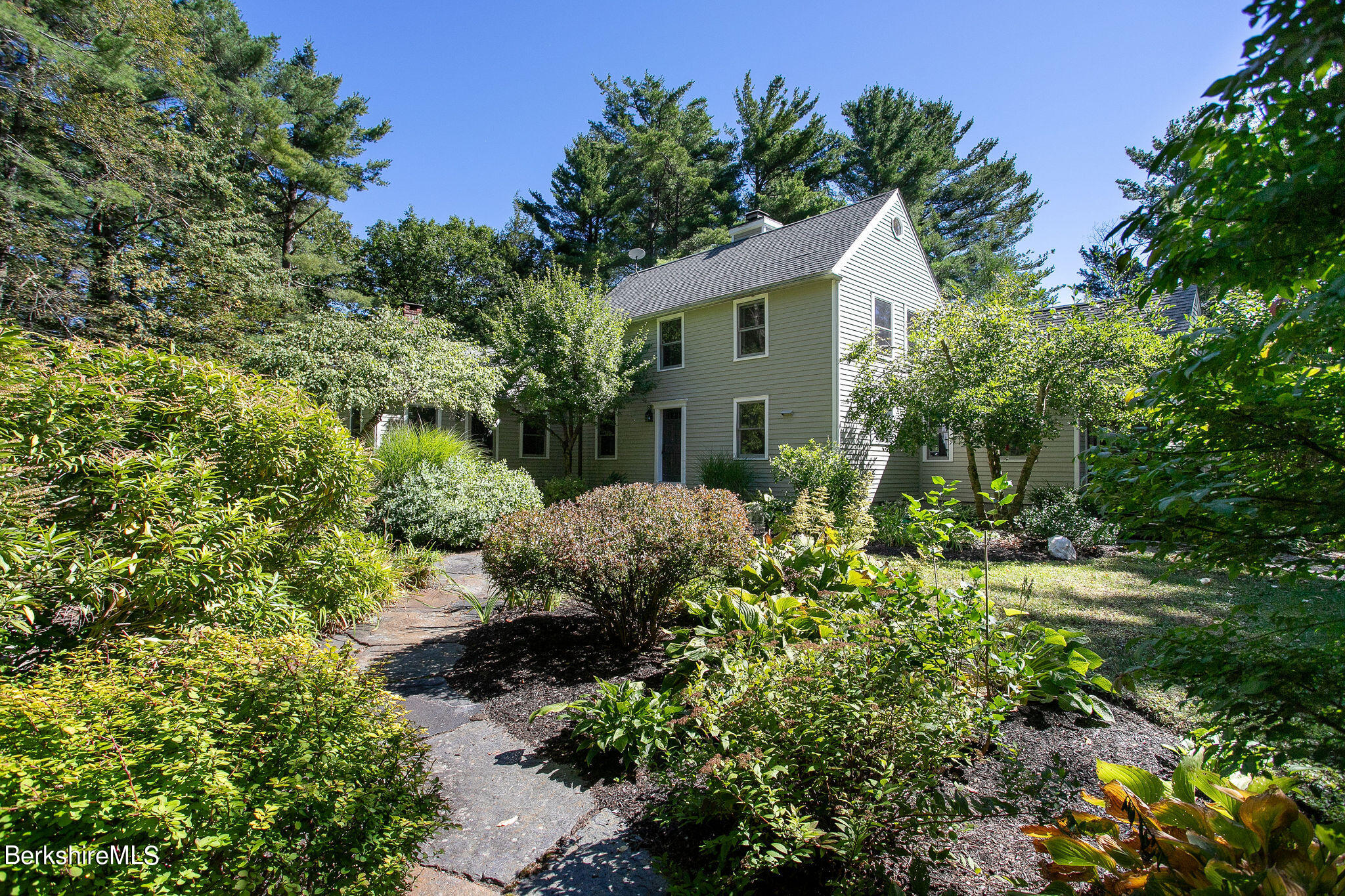 a view of a house with a yard and potted plants