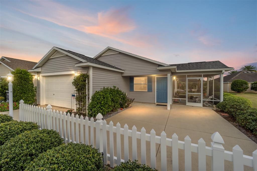 a view of a house with wooden fence next to a yard