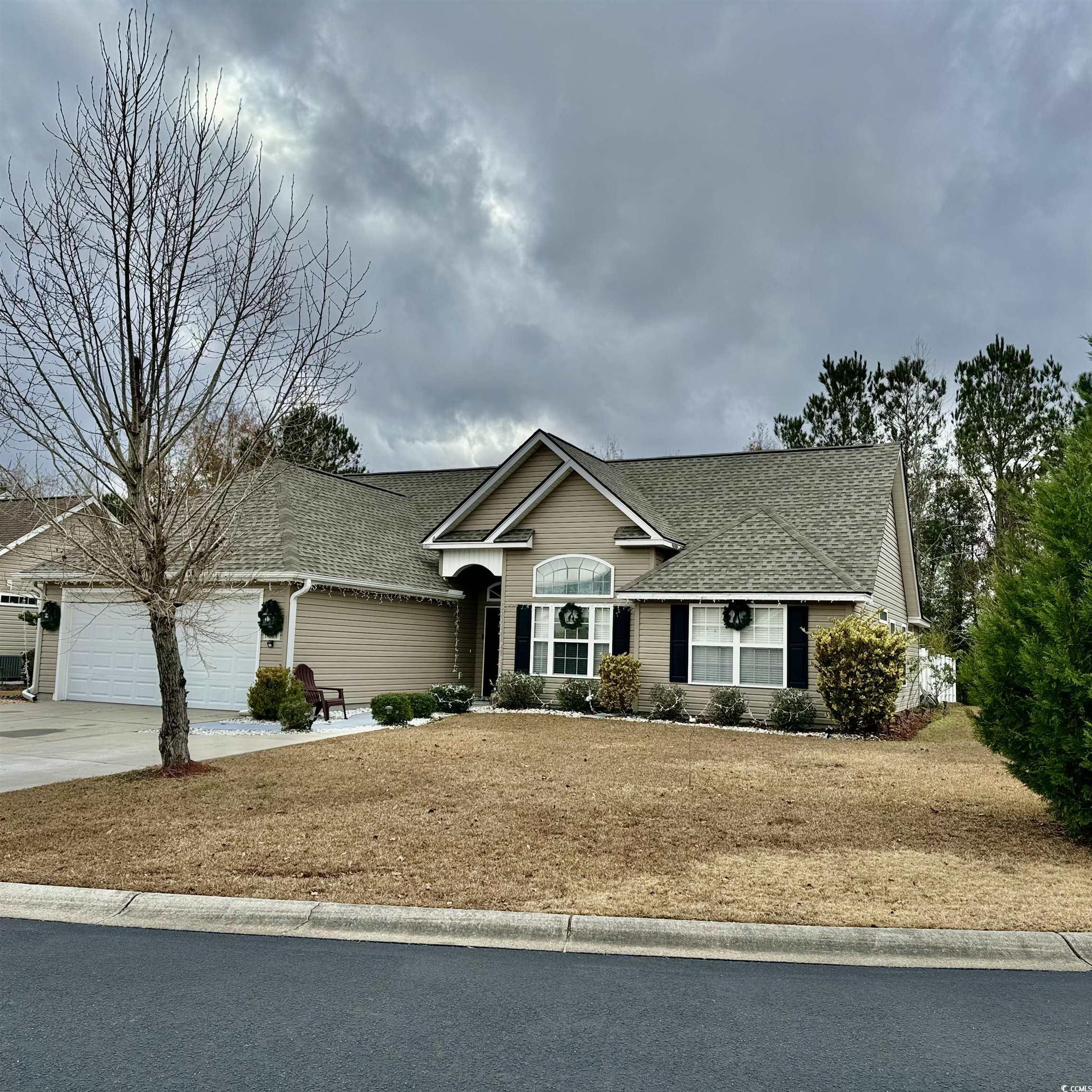 Single story home with a garage and a front lawn