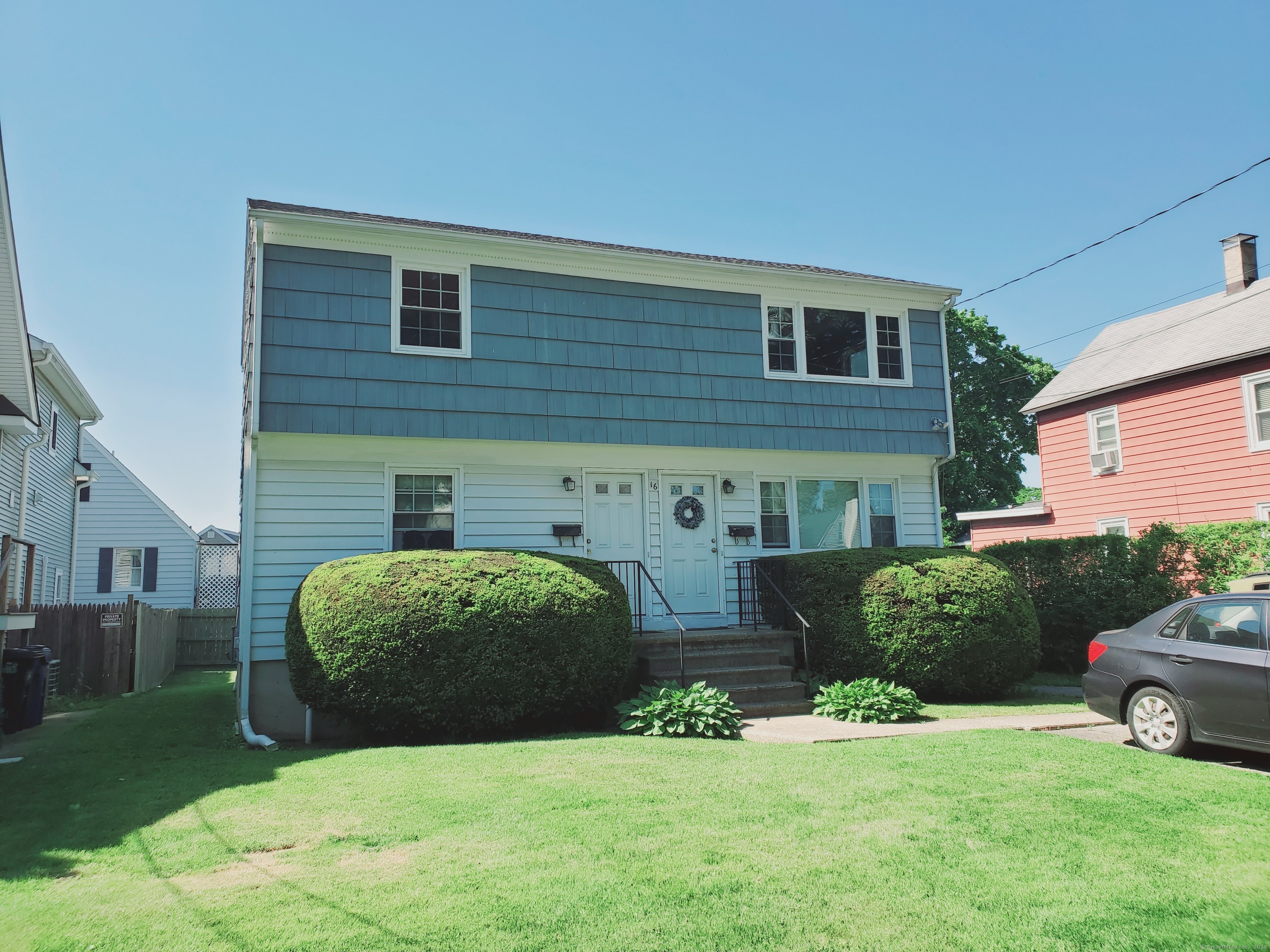 a front view of a house with a garden and plants