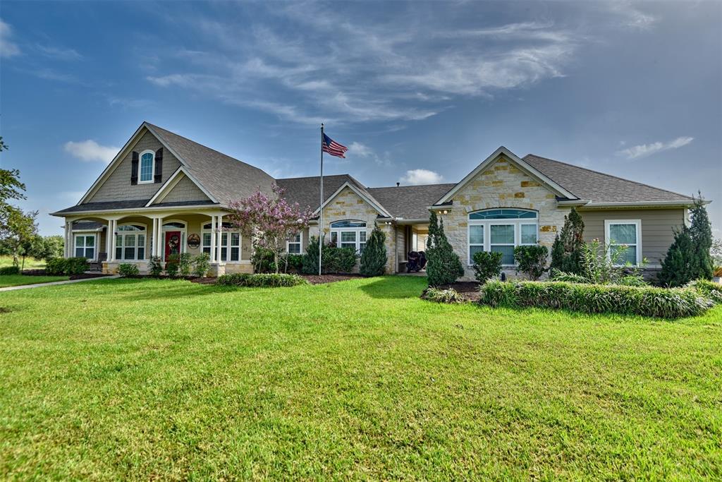 a front view of a house with yard and green space