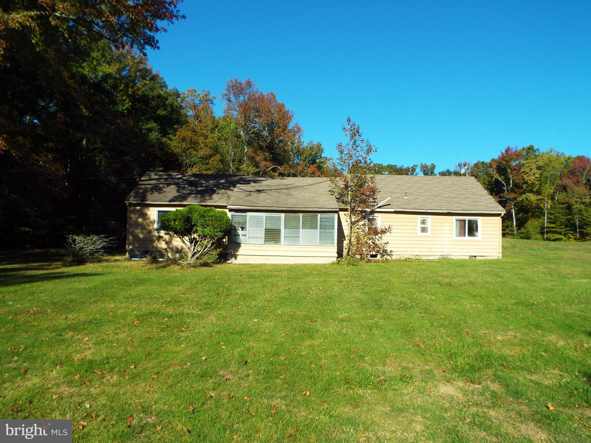 a view of a house with a big yard and large trees