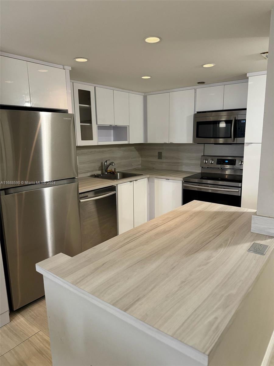 a kitchen with stainless steel appliances granite countertop a refrigerator sink and stove