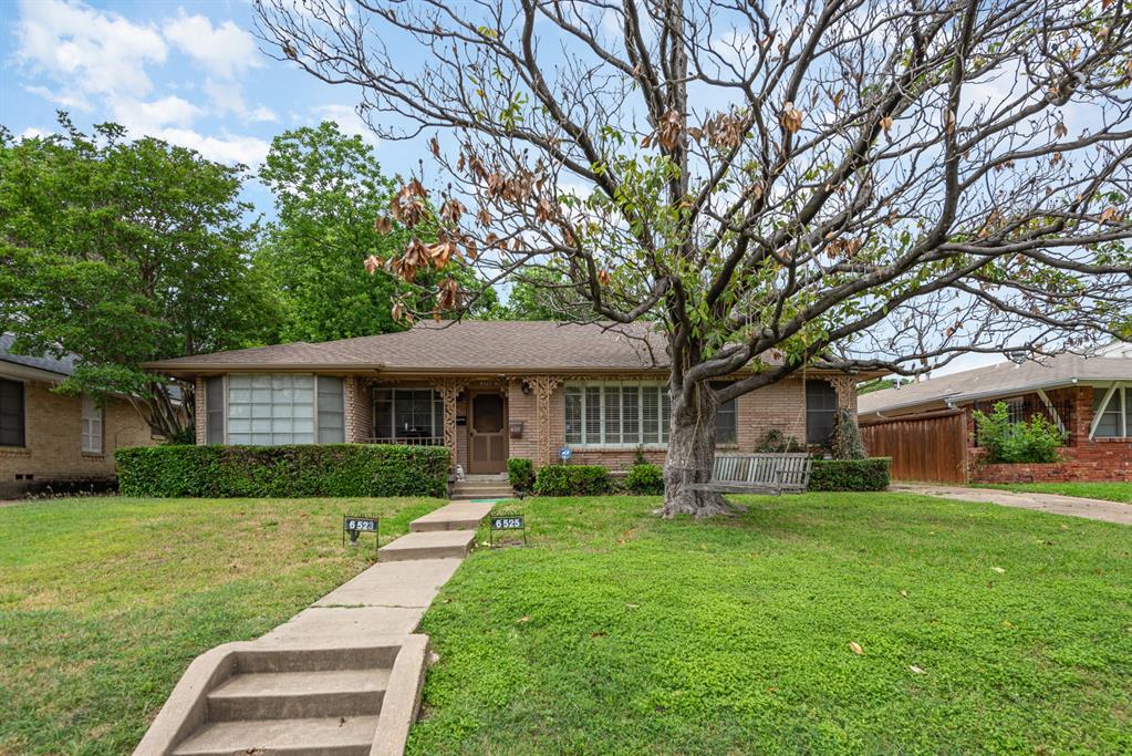 a front view of a house with yard and green space